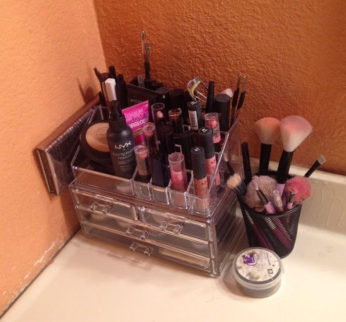 Everything is meticulously organized in a storage unit with shelves and designated spaces for brushes.