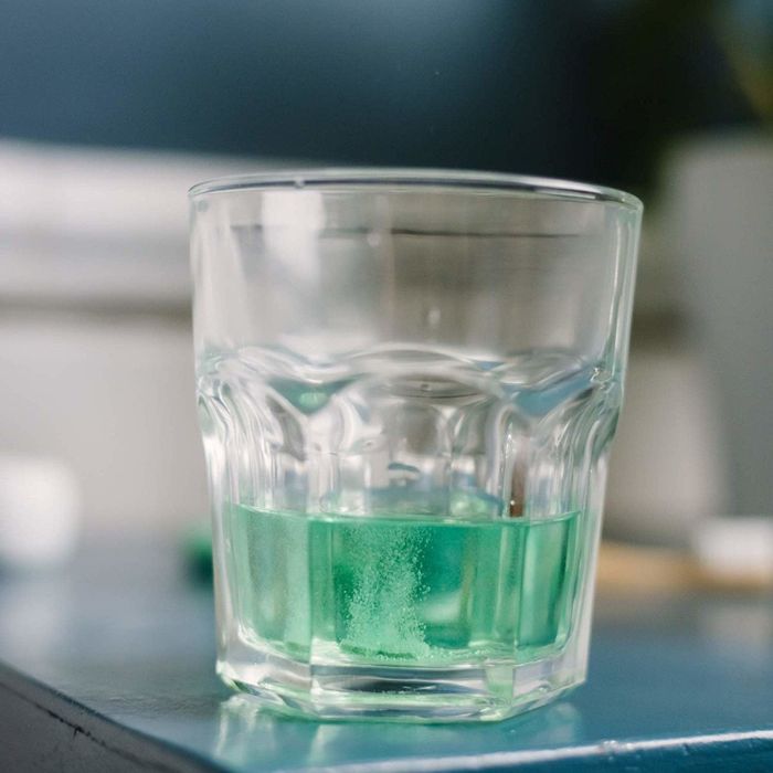 glass containing green mouthwash