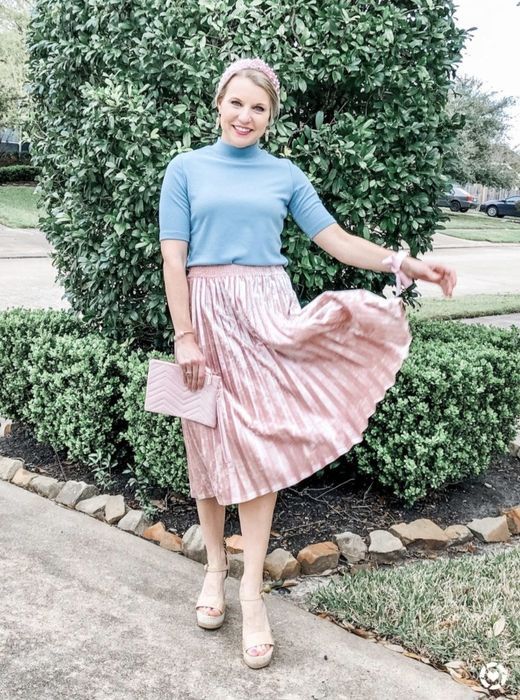 A photo from the reviewer showcasing the blue short-sleeve turtleneck paired with a pleated skirt