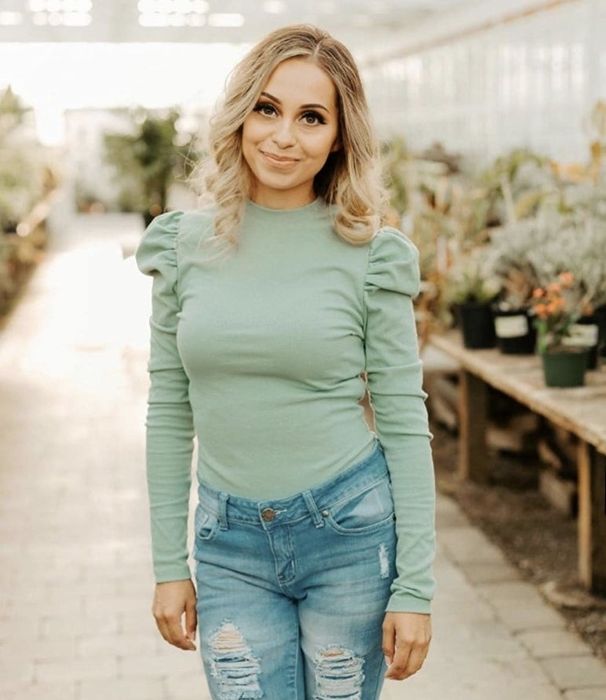 A reviewer’s photo showcasing the seafoam green top tucked into a pair of jeans.