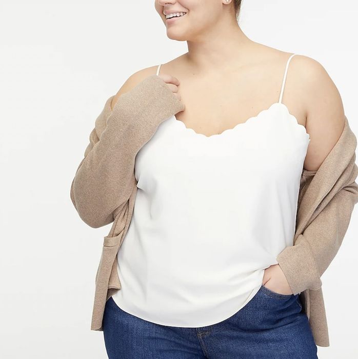 Model wearing the white scalloped cami with a stylish sweater