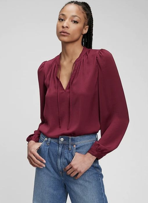 Model styled in a red top tucked into jeans.
