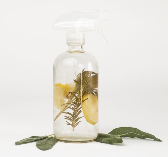 A transparent bottle of cleaner infused with refreshing rosemary and lemon.