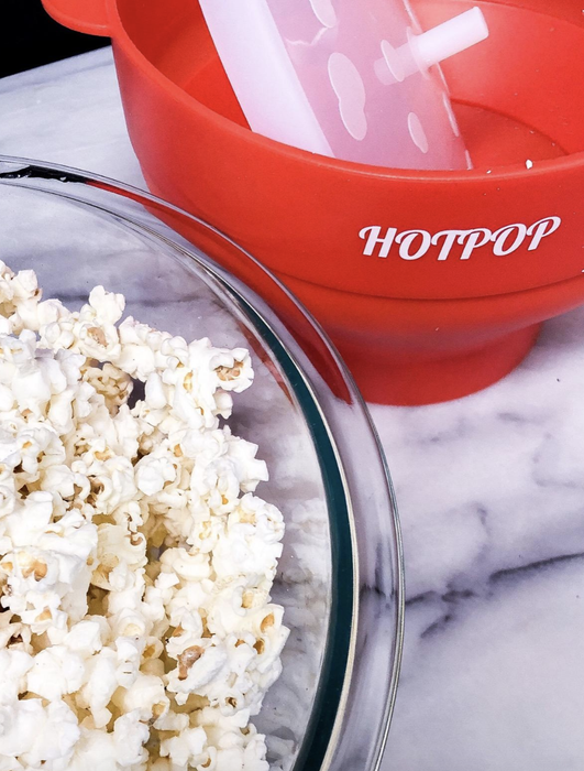 A reviewer showing off the red popcorn maker.