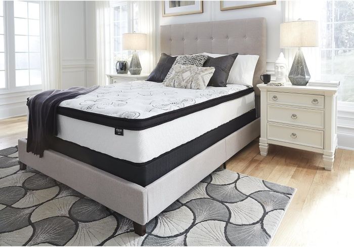 A king-size bed featuring a plush upholstered headboard, set in a tastefully decorated bedroom that exudes elegance and comfort.
