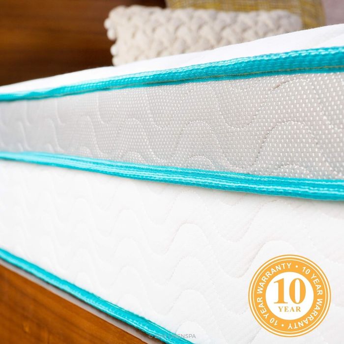 A detailed close-up of a mattress, featuring a 10-year warranty label, emphasizing its texture and edge design.