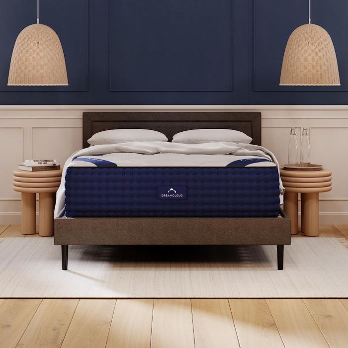 A DreamCloud mattress positioned on a bed frame in a beautifully styled bedroom, accompanied by bedside tables and lamps, enhancing the room's overall elegance.