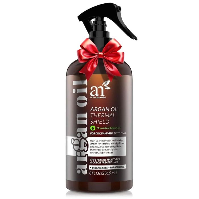 A bottle of Argan Oil Thermal Shield spray with a red bow, perfect for dry, damaged hair. Contains 8 fl oz and is safe for color-treated hair.