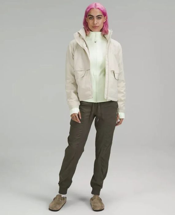 Model wearing the dark green joggers paired with Birkenstock clogs
