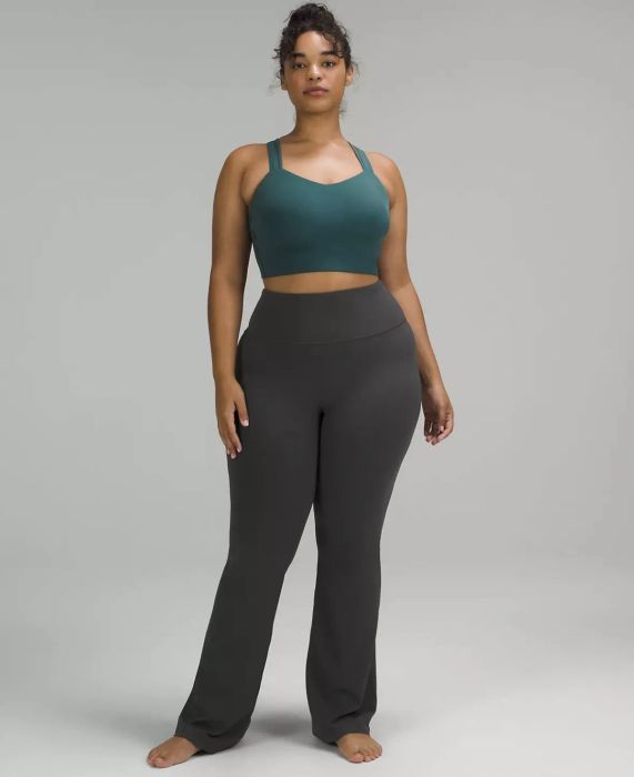Model dressed in grey flared yoga pants paired with a teal cropped tank
