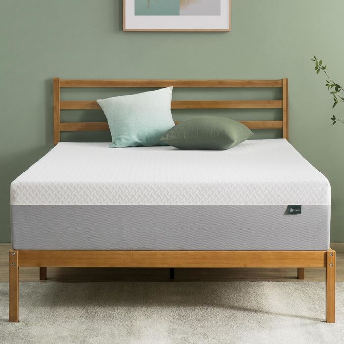 Chic wooden bed with a tidy mattress and two pillows, set in a minimalist room that perfectly highlights the surrounding decor