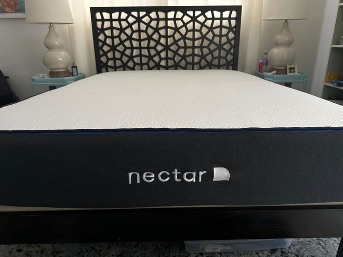 Nectar mattress resting on a platform bed with a sleek, geometric-patterned headboard in a stylish bedroom arrangement