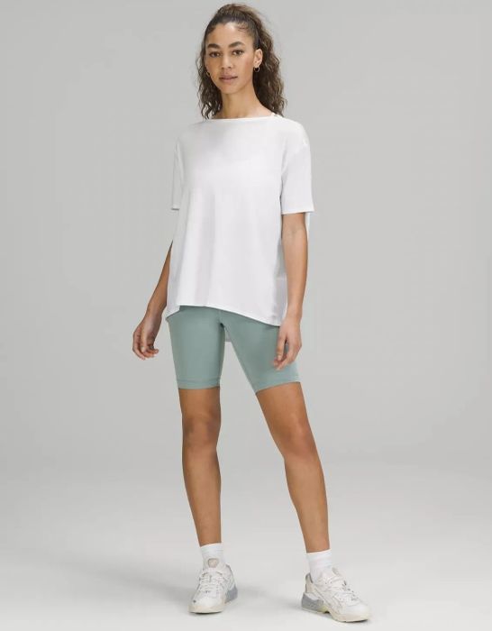 Model showcasing the white tee paired with biker shorts.