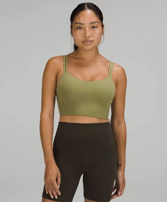 Another model wearing the olive green sports bra paired with high-rise shorts, captured from the front.