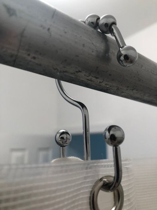 A close-up image of the double hook shower curtain hook in action.