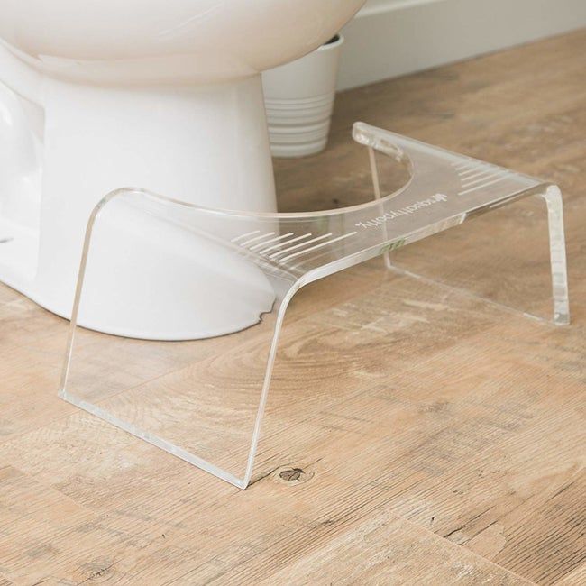 A clear acrylic stool that fits conveniently in front of a toilet