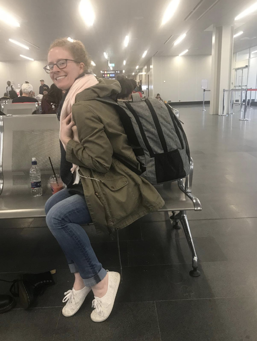 A reviewer wearing a gray backpack filled with items.