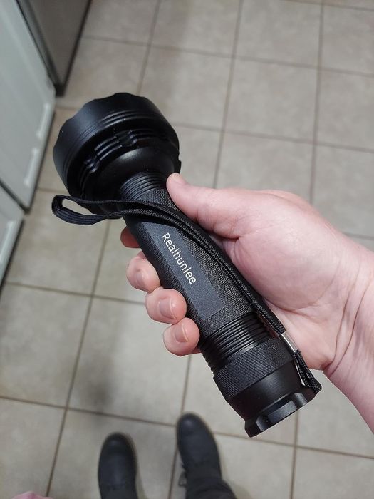 A reviewer holding the LED flashlight