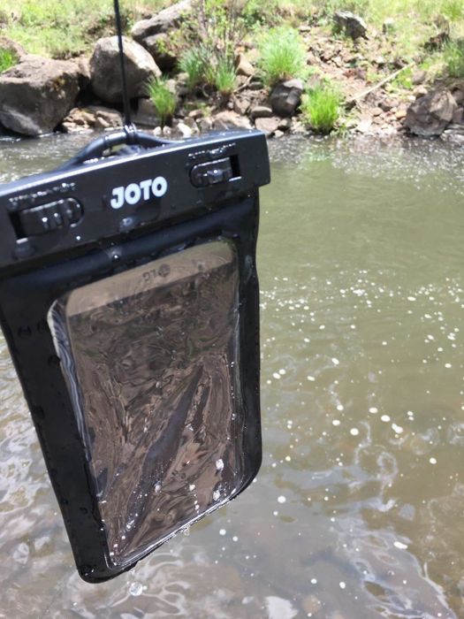 A reviewer image showing their phone securely in the case after being submerged in the river.