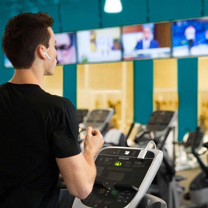 A model at the gym using AirPods along with the AirFly device.