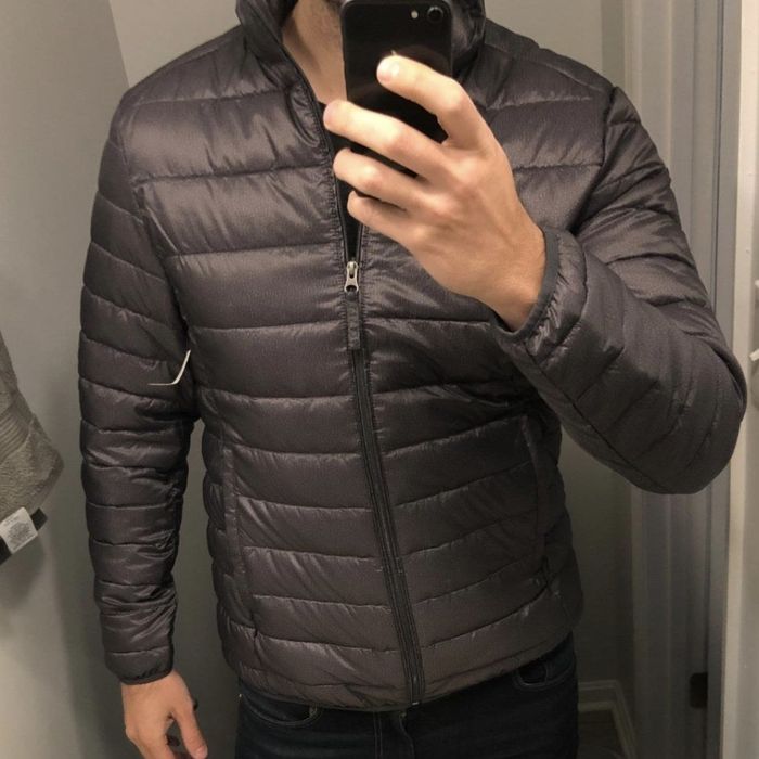 Reviewer snapping a selfie while wearing the grey puffer
