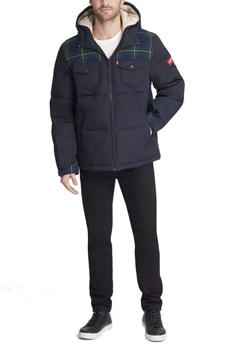 The same model is shown again, wearing the navy parka.