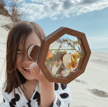 A child gazing through the kaleidoscope, mesmerized by the shifting patterns.