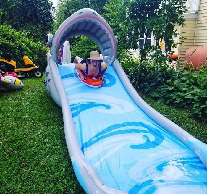 A reviewer riding down the shark water slide