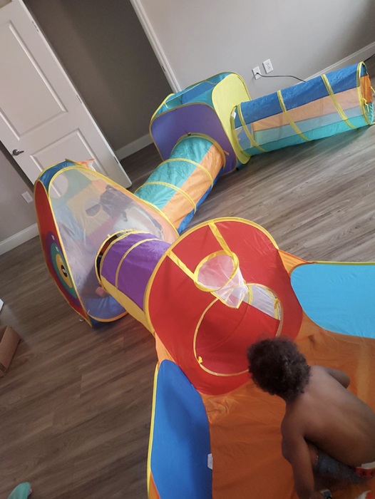 A child having fun inside a tunnel play set.