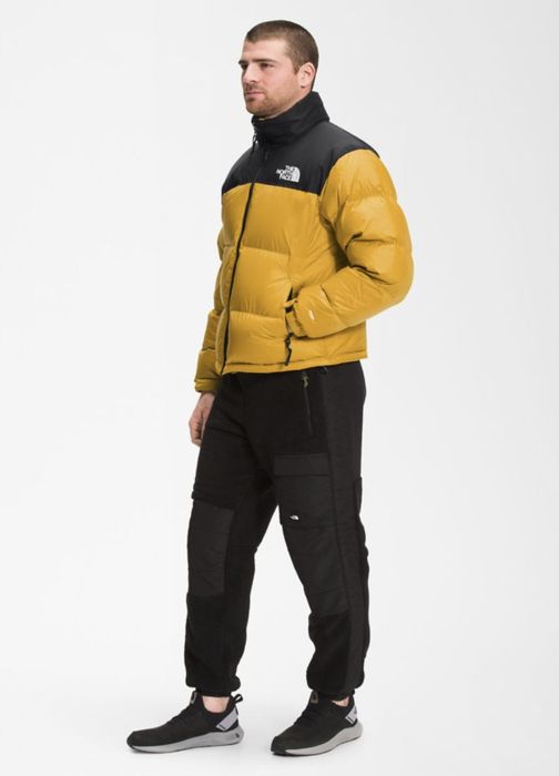 Same model in a yellow jacket paired with sweatpants