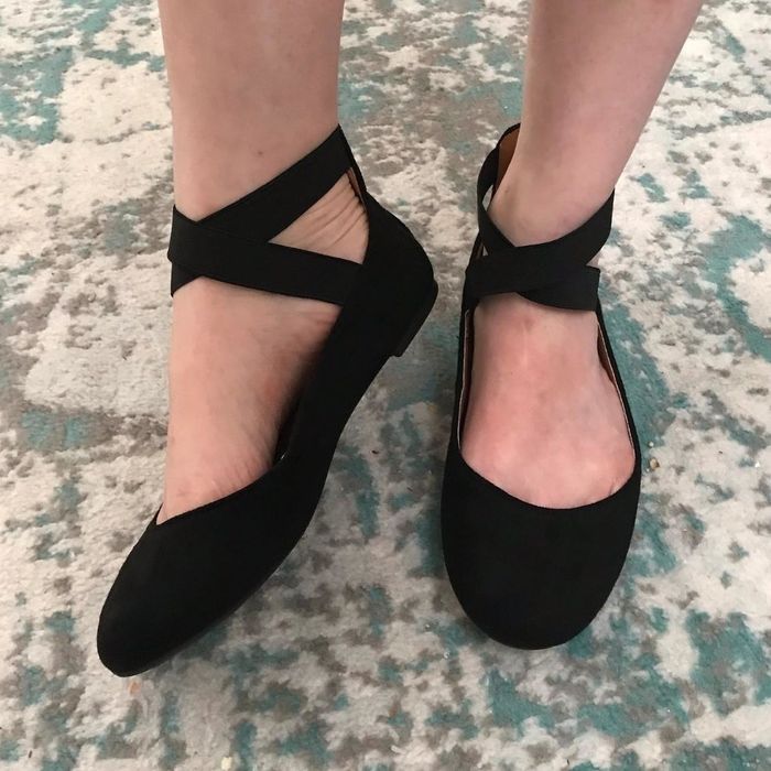 A person wearing black strappy flats, an essential addition for any versatile wardrobe.