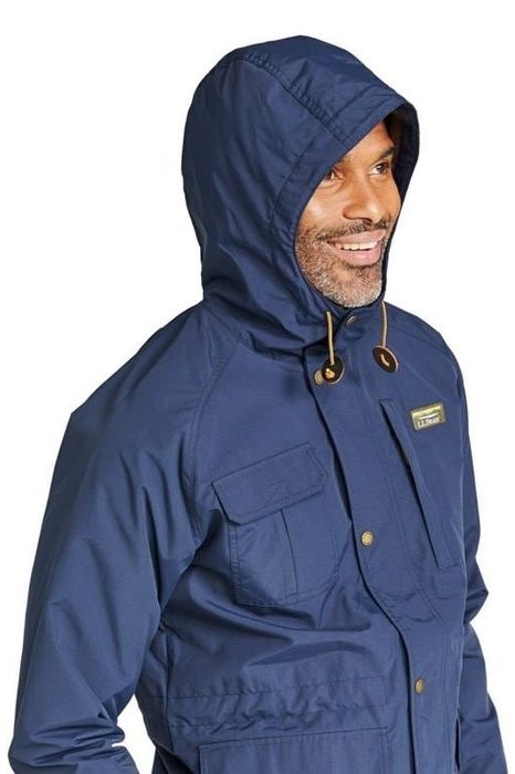 The same model is shown wearing the blue jacket with the hood up.