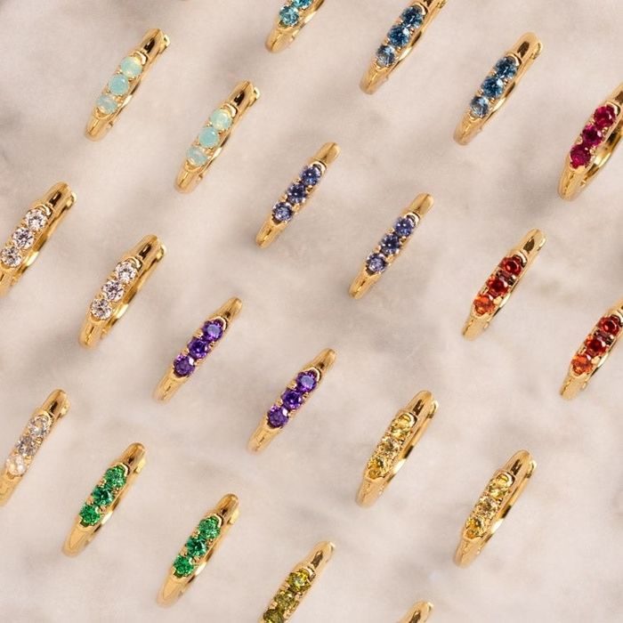 A collection of gold huggie hoop earrings in various elegant styles.