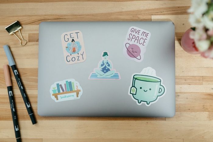 a laptop covered in a variety of cozy-themed stickers