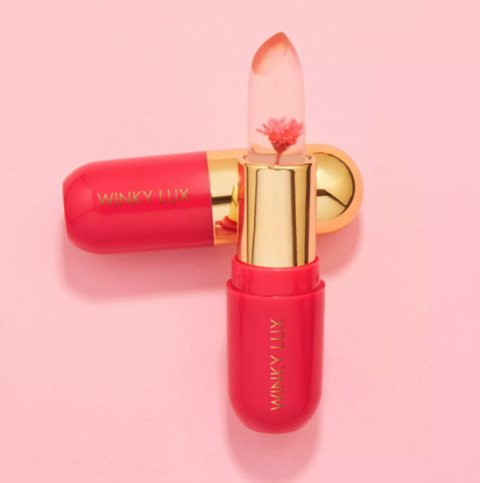 A transparent lip balm encasing a tiny real flower inside, adding a magical touch to an everyday beauty essential.