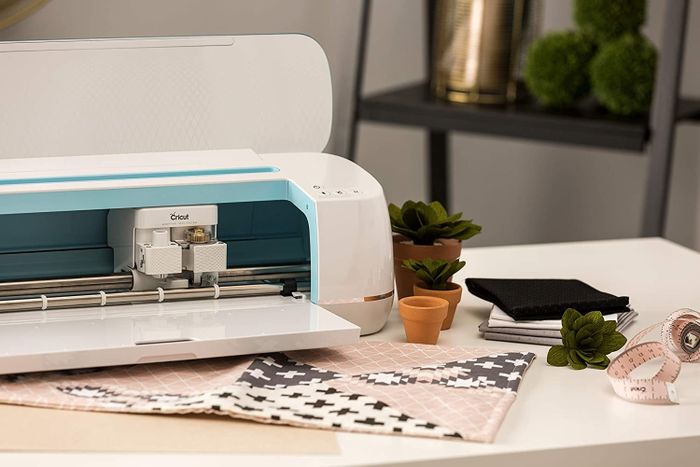 A Cricut Maker machine in a crisp white and soft blue color scheme, ready to take crafting projects to the next level.