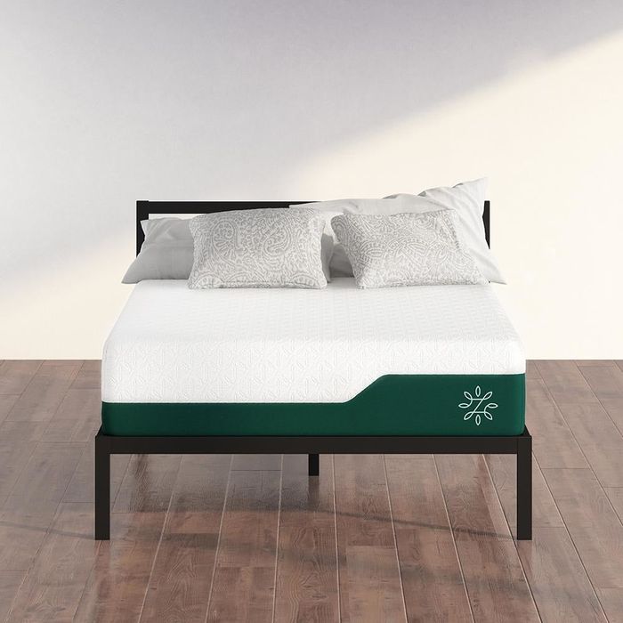 mattress with a green base on a bed frame