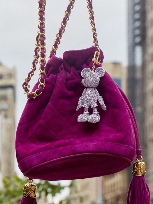 A shimmering purple rhinestone Mickey Mouse keychain attached to a bag, adding a touch of fun.