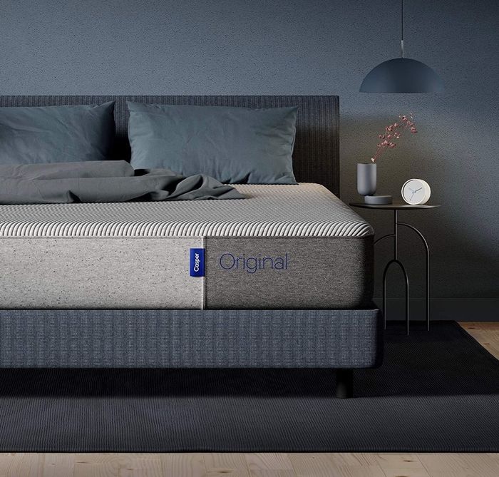 A Casper Sleep memory foam mattress placed on a gray bed platform