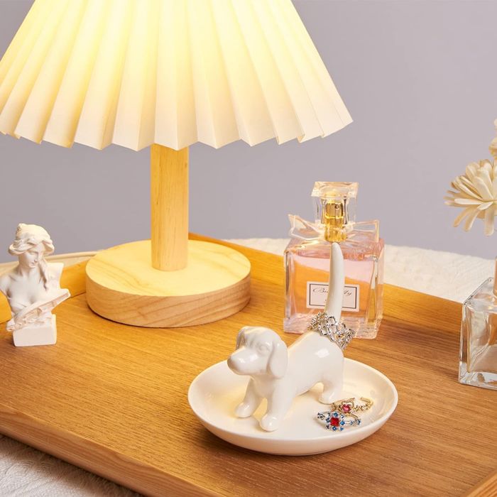 The white ceramic dog-shaped dish holding jewelry.