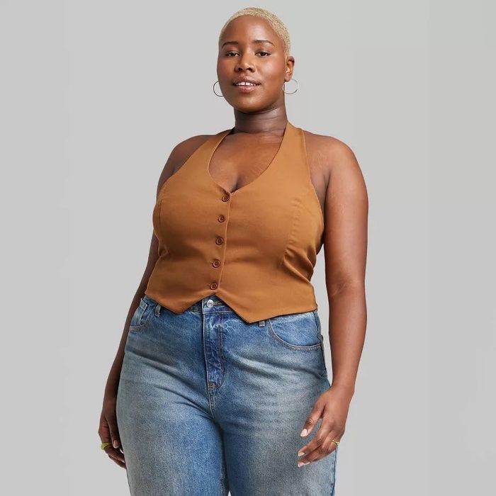 Model wearing a button-down vest top paired with jeans.