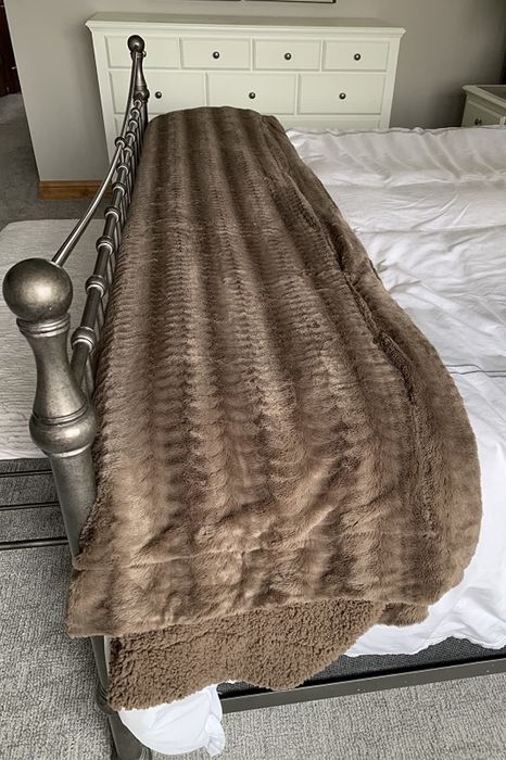 A photo from the reviewer featuring a brown blanket spread out on a bed.