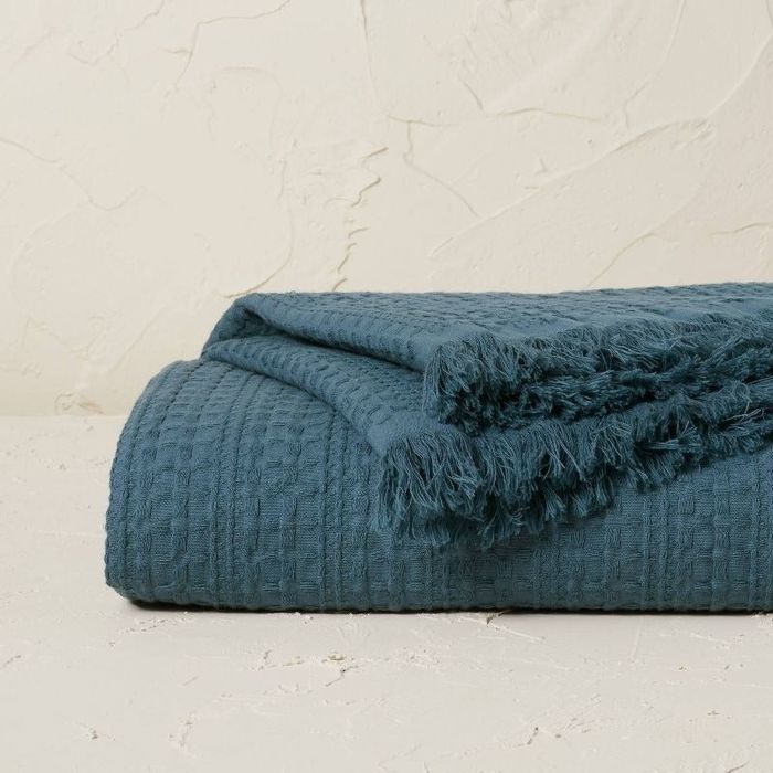 a neatly folded blue blanket with a rich, textured design