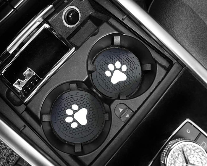Two silicone coasters with white paw prints, perfectly fitting into car cup holders.