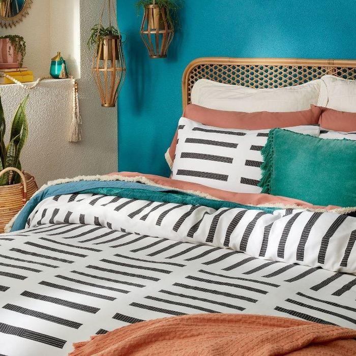 A black and white comforter elegantly displayed on a well-decorated bed.