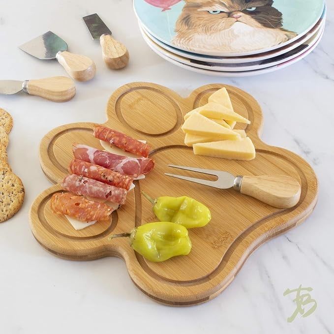 Paw-shaped bamboo charcuterie board with food arranged on it