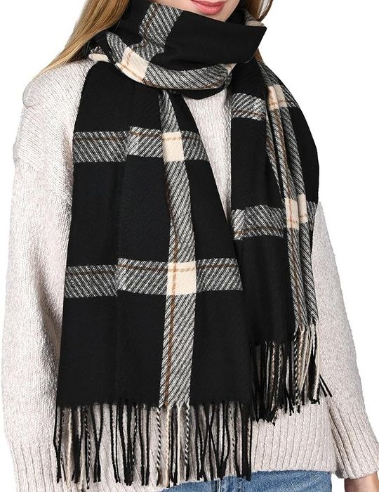 Model wearing a black and white plaid scarf with fringe.