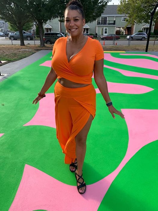 A photo of the reviewer rocking the orange Vetior cross wrap crop top paired with a matching orange skirt.