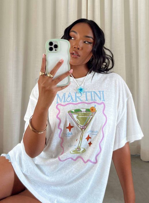 A model showcasing the shirt featuring an illustration of a martini on the front.