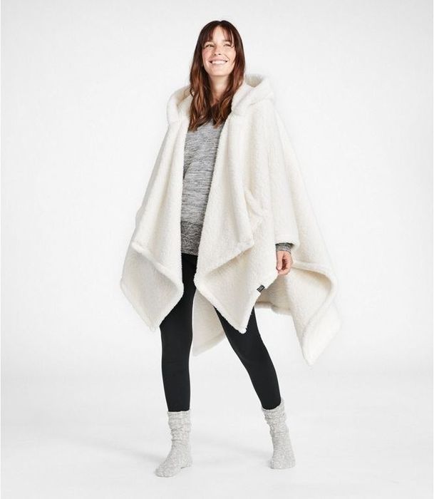 A model wearing a white sherpa blanket